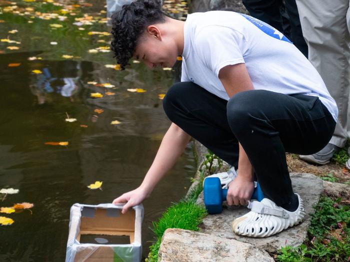 Student testing a prototype boat for the Cardboard Regatta